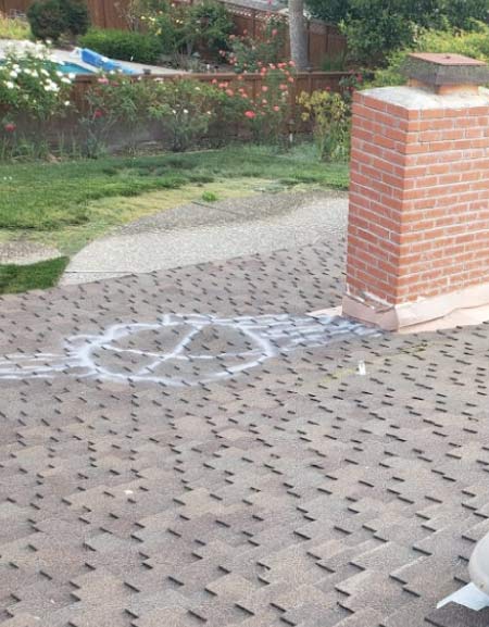 metal-roof A close-up view of damaged asphalt shingles on a residential roof, marked with white spray paint to indicate an area requiring repair by a roofing company in Antioch, CA