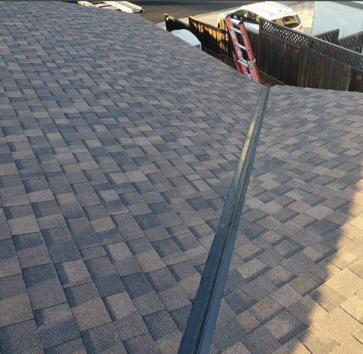 A warm-toned, multi-layered brown asphalt shingle roof installation, showing the finished ridge lin, installed by a roofing contractor in antioch, ca