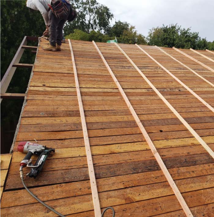 roof fixers on the roof ready to replace a residential roof with asphalt shingles
