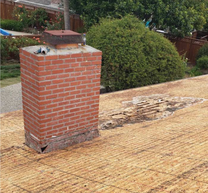 rot roof with a chimney ready to be repaired