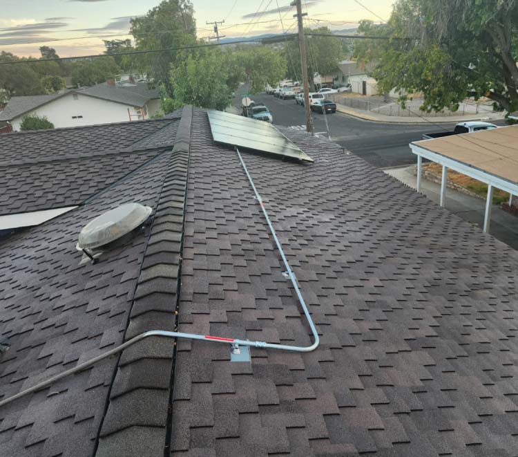 Wide shot of a durable dark grey asphalt shingle roof replacement by a GAF-certified roofing company, showcasing clean architectural lines and solar readiness for a home in Alameda County.