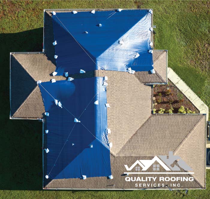 High-quality industrial-grade blue tarps installed by Quality Roofing Services, Inc. providing 24/7 emergency roofing protection for a homeowner in the East Bay to mitigate storm damage.