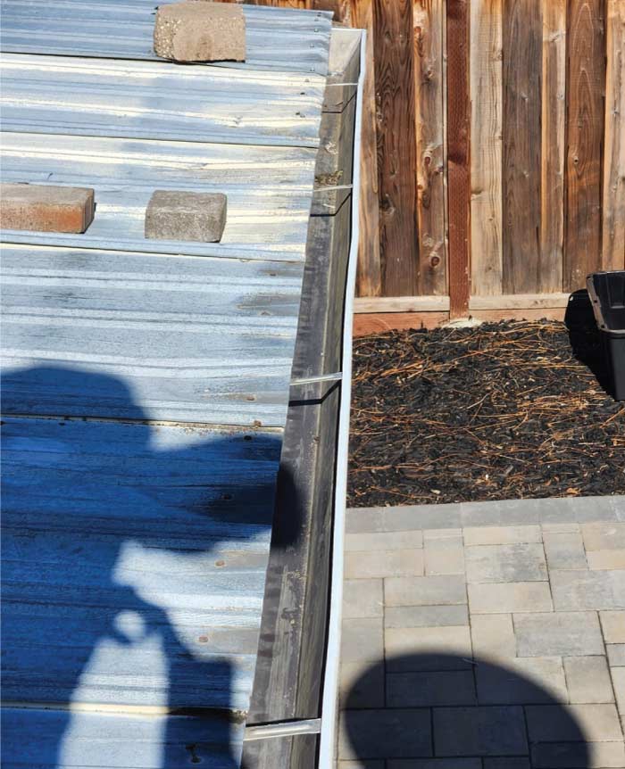 Side view of a durable metal roof system integrated with a high-capacity gutter, providing superior water management and long-term durability for a commercial or residential structure.